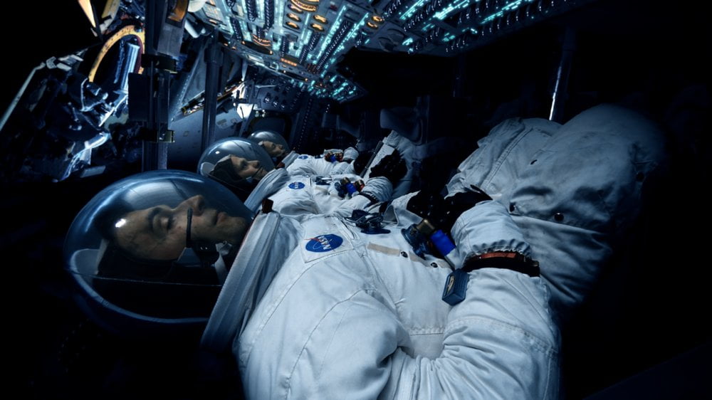 Drei Astronauten im Cockpit einer Kommandokapsel beim Flug zum Mond