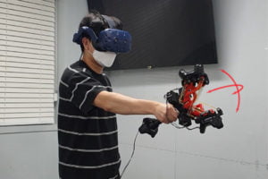 Ein Mann mit VR-Brille demonstriert einen aufwendigen Haptik-VR-Controller