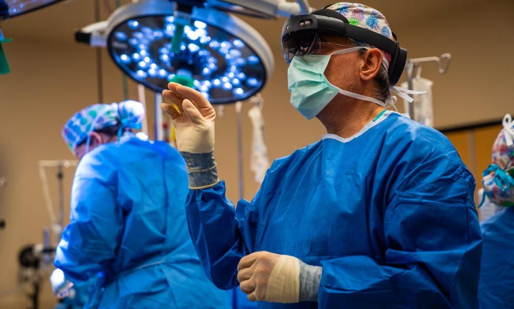 Ein Chirurg steht im OP-Saal mit Hololens 2.