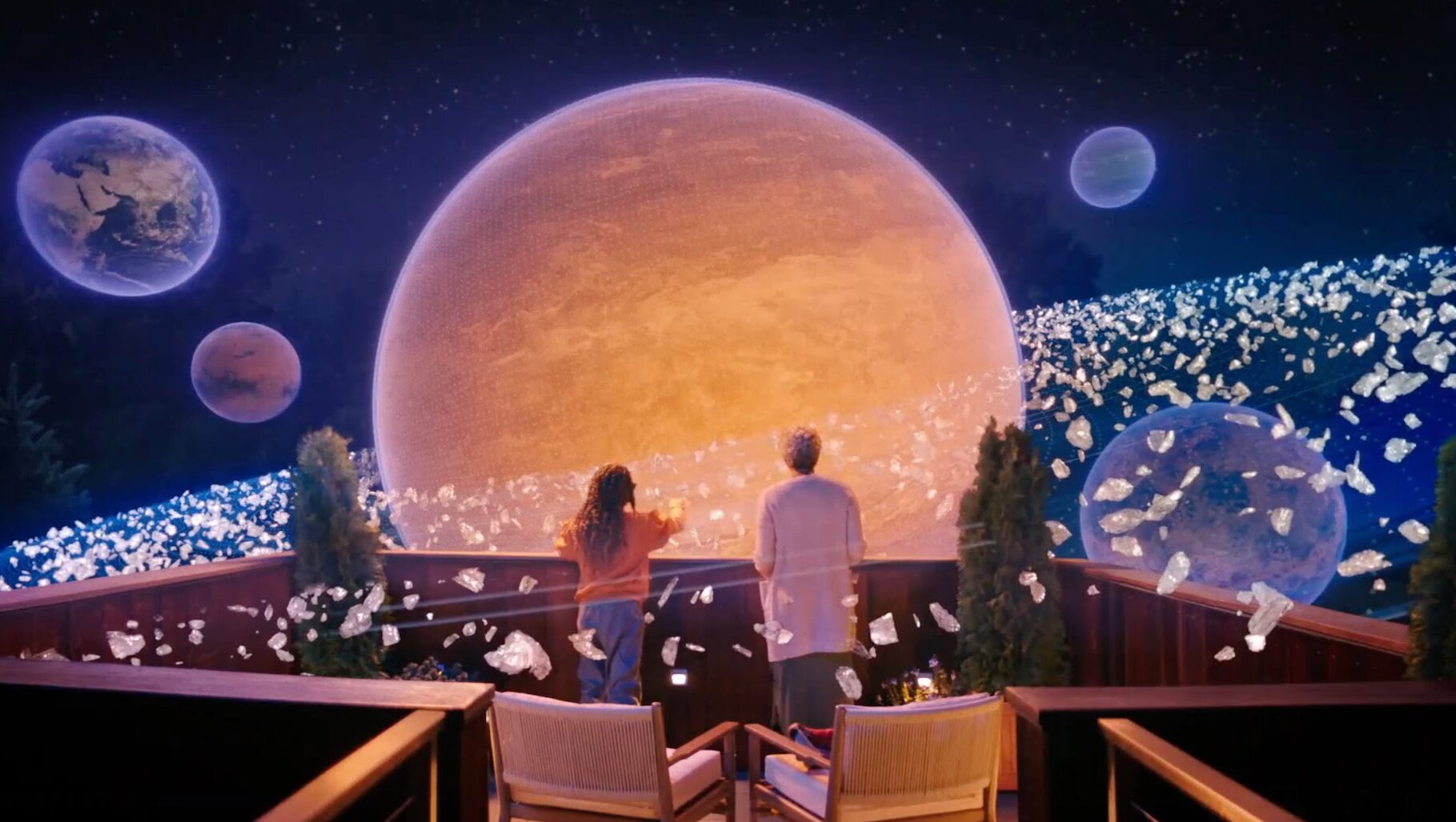 Ein Kind und eine Frau schauen auf einem realen Balkon ein digitales Weltall an.