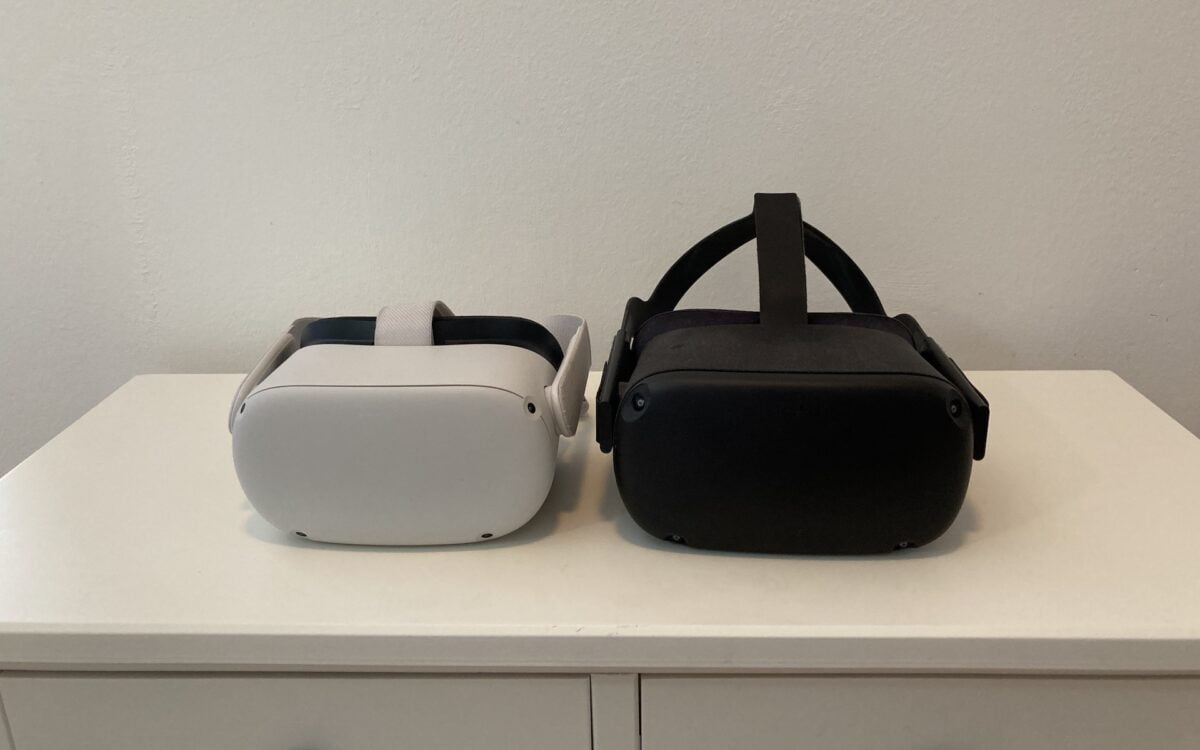 Eine Meta Quest 2 (weiß, links) liegt neben einer Oculus Quest 1 (schwarz, rechts) auf einem Schränkchen.