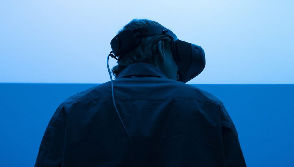 Ein Mann mit VR-Brille auf dem Kopf steht mit dem Rücken zur Kamera.