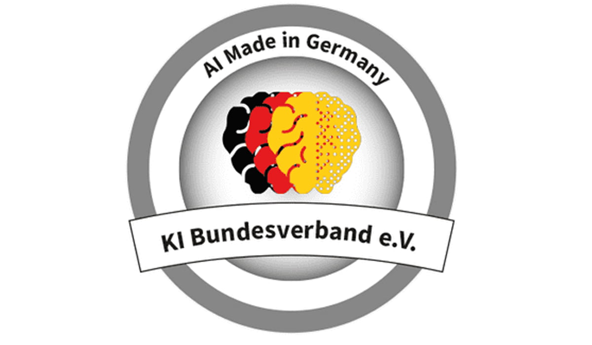 Das Gütesiegel des KI Bundesverbands - drei halb biologische, halb künstliche Gehirne übereinander in schwarz, rot, gold und dem Schriftzug "AI Made in Germany"