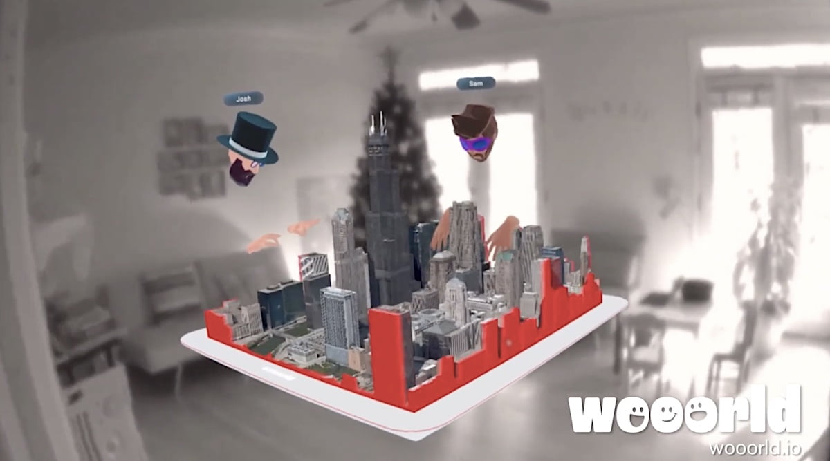 Zwei Avatare interagieren mit einem 3D-Kartenausschnitt inmitten eines realen Wohnzimmers.