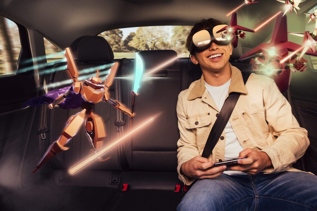Ein Mann erlebt Virtual Reality mit der Plattform Holoride auf dem Rücksitz eines Autos.