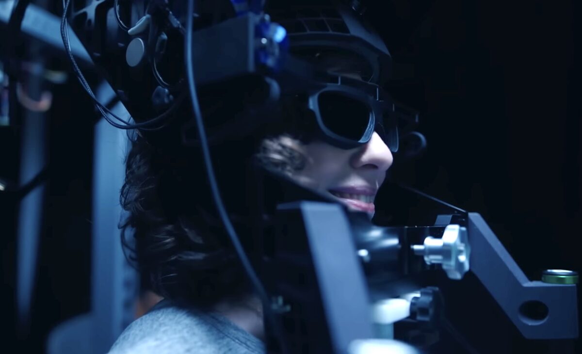 Frau in Meta sperrigem Verzerrungssimulator mit 3D-Brille und Handgriffen.
