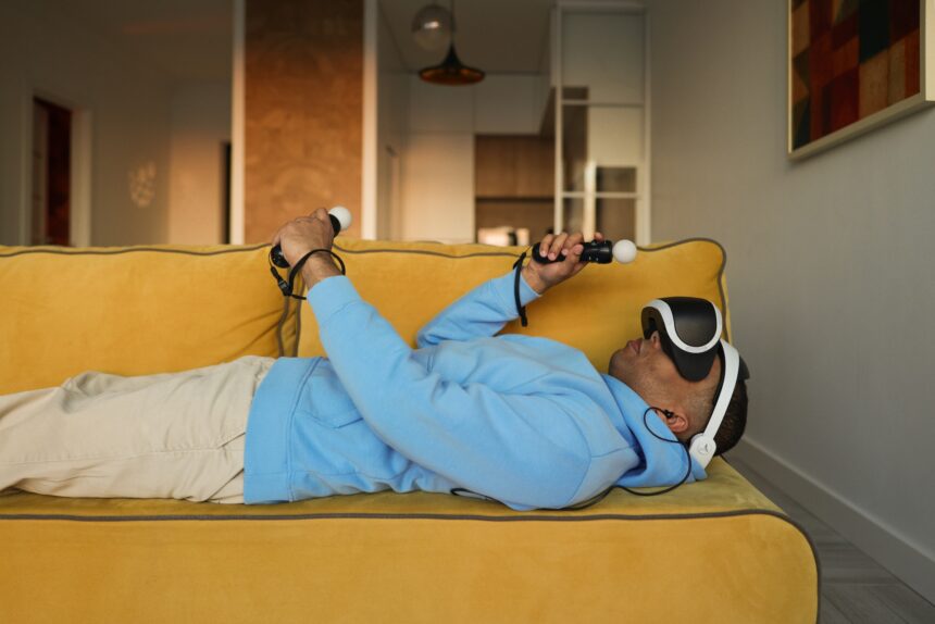 VR-Nutzer mit Playstation VR auf Couch liegend.