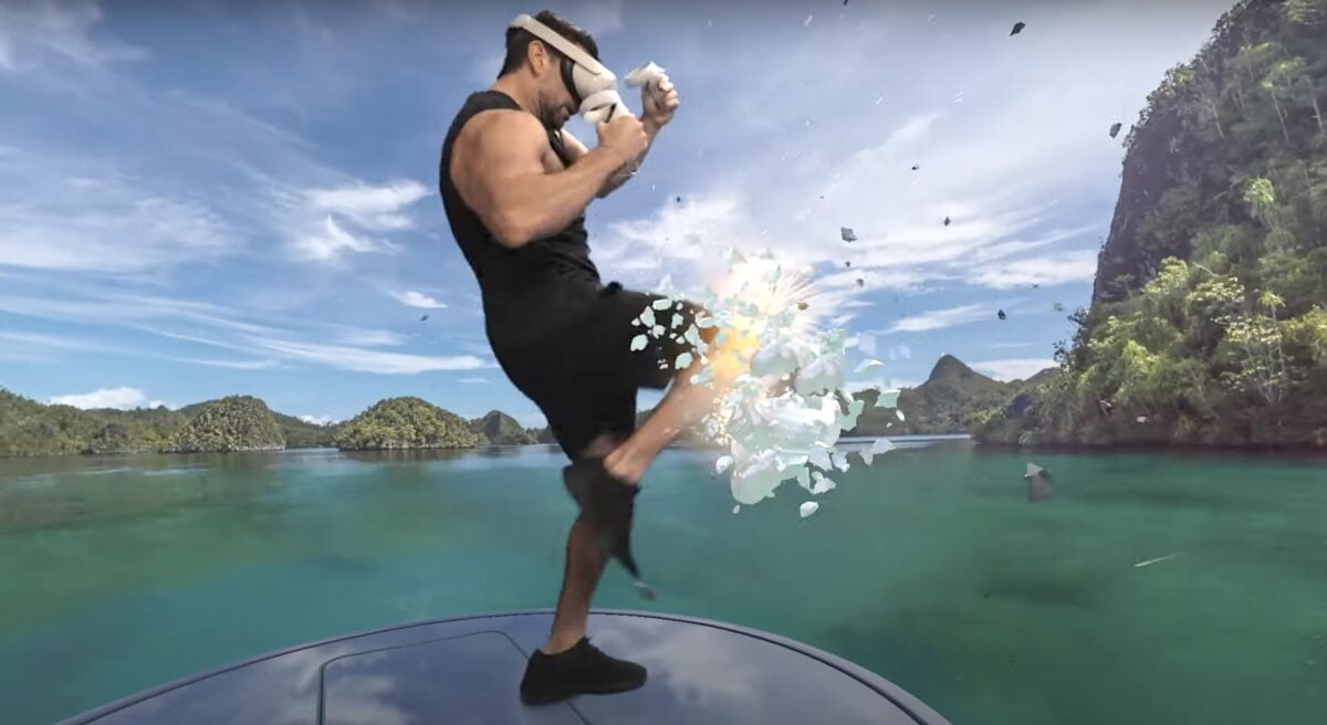Mann mit Quest 2 hebt sein Knie und zertrümmert eine Note in einer Karibik-Landschaft der VR-App Supernatural.