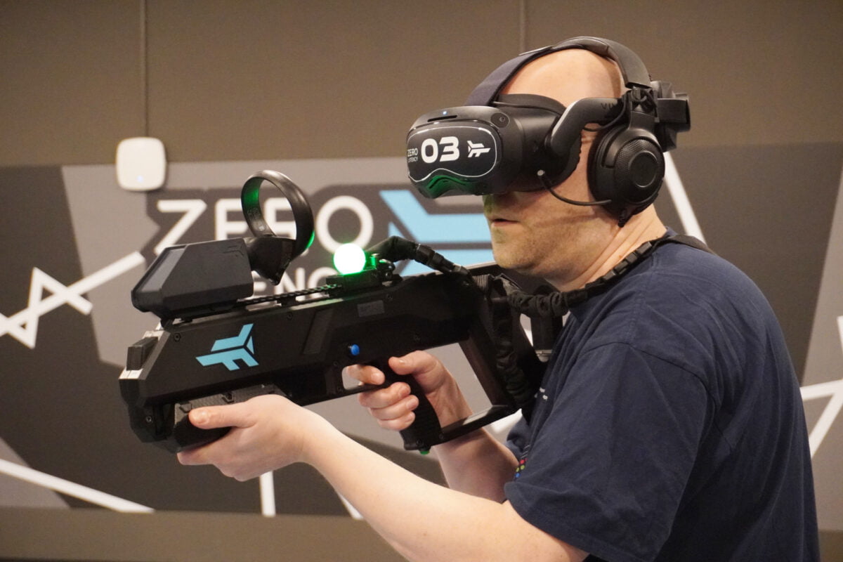 Mixed-Autor Jan Wöbbeking trägt in der VR-Arcade Zero Latency eine Vive Focus 3, Kopfhörer und einen Waffen-Controller.