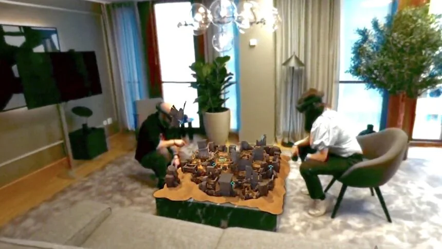 Zwei Demeo-Spieler spielen anscheinend eine lokale Multiplayer-Version von Demeo. Das Spielbrett ist auf einen Tisch projiziert.