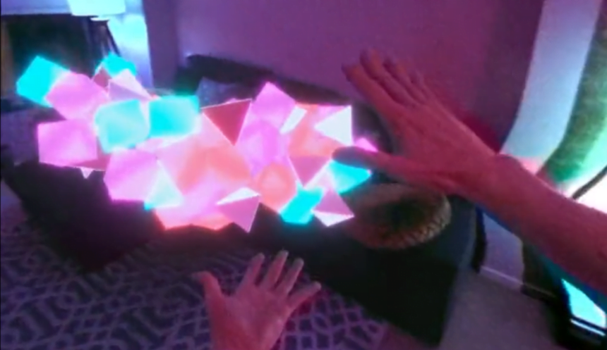 Zwei Hände ziehen in der AR-Demo glühende Blöcke aus Computergrafik durch die Wohnung.