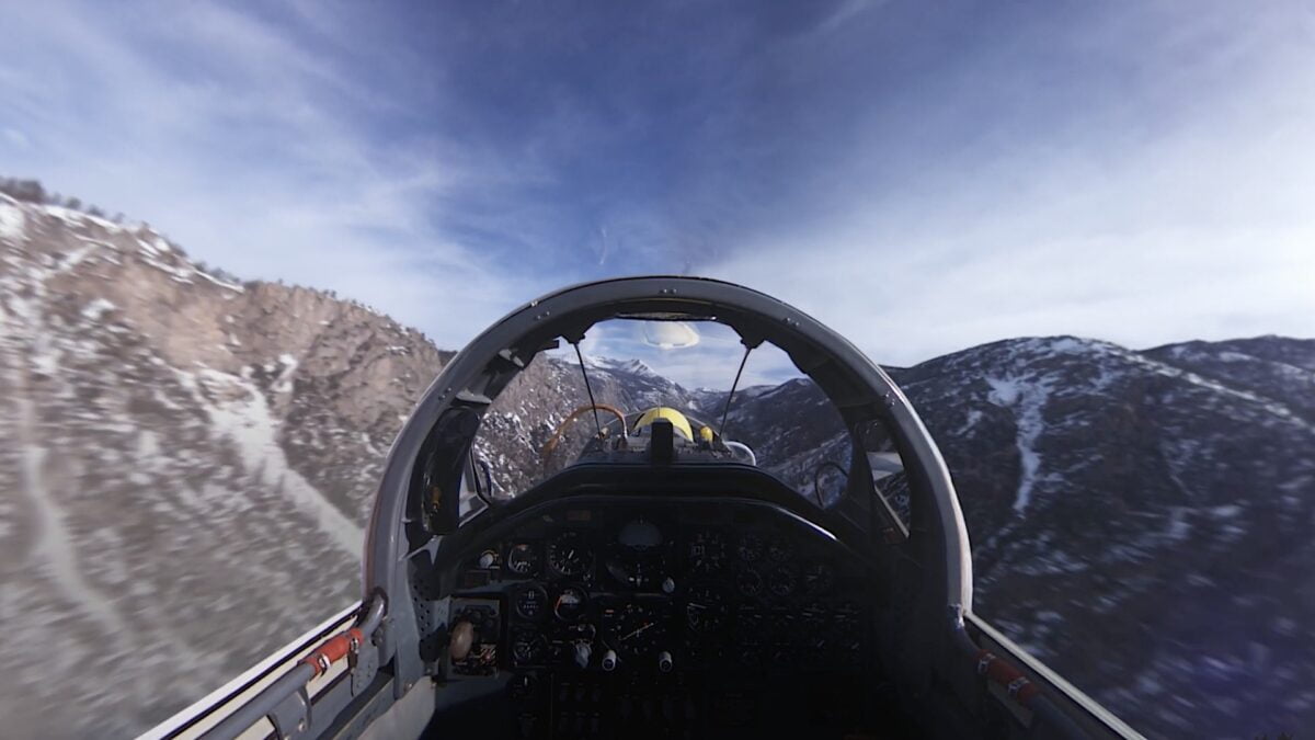 Auf dem Kopilotensitz eines Hyperschall-Jets, rings umher Berglandschaft.