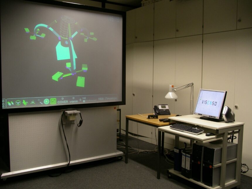 Ein fahrbarer Bildschirm für 3D-Visualisierungen steht links, rechts davon ein PC auf einem Computertisch
