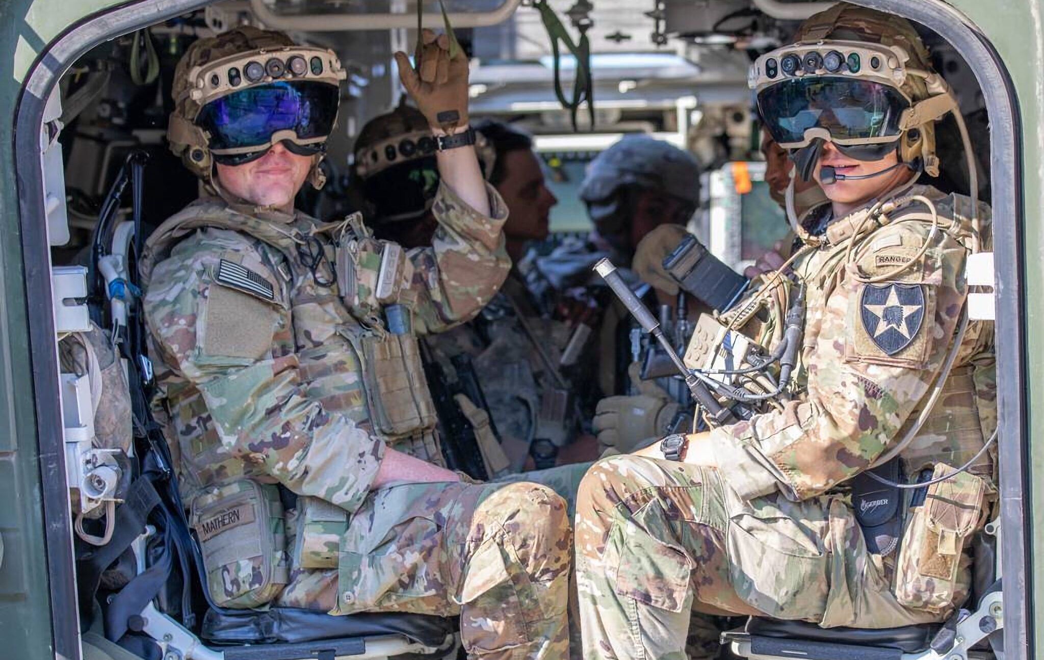 Soldaten sitzen in eime Hubschrauber und schauen heraus, sie tragen große Helme mit vielen Kameras darin und einem Visier. Das ist die IVAS-AR-Brille.