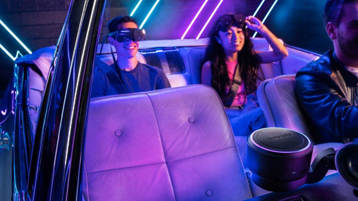 Zwei Mitfahrende auf der Auto-Rückbank nutzen VR-Brillen mit dem an der Windschutzscheibe befestigten System Holoride Retrofit.