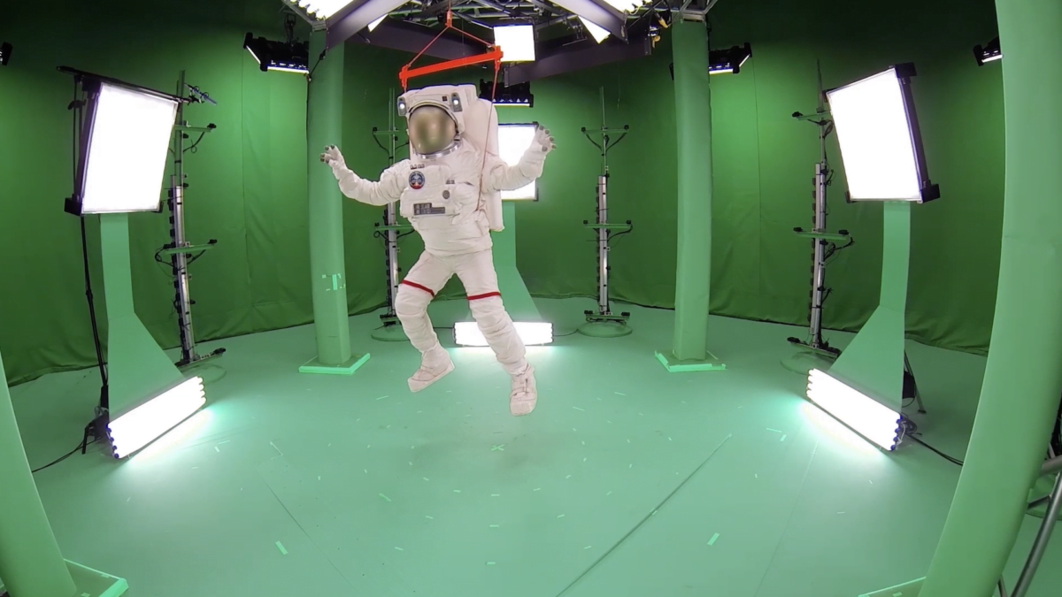 Ein an einem Gerüst aufgehängter Mann im Astronautenanzug in einem von Microsofts Capture Studios.