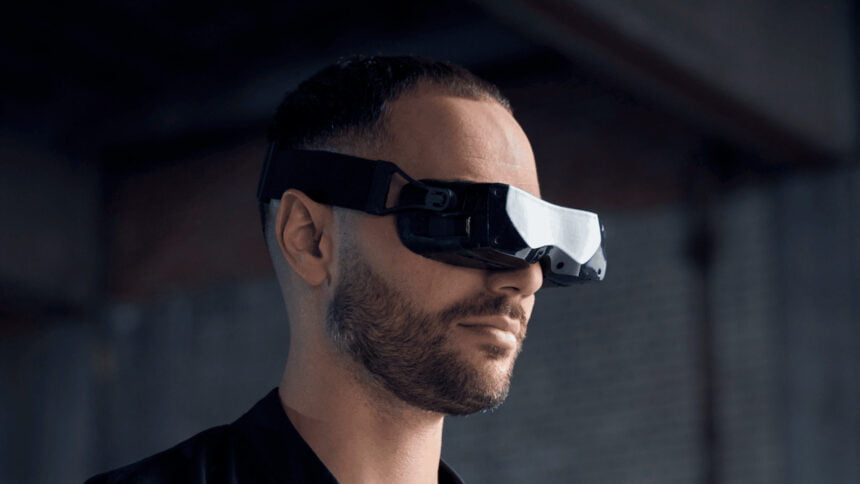 Ein Mann trägt die winzige PC-VR-Brille Bigscreen Beyond.