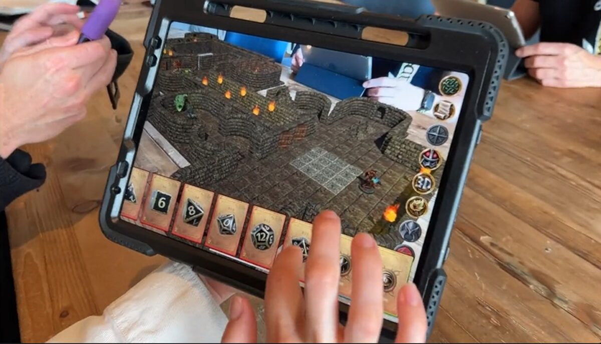 Auf einem Tablet wird das Spielfeld eines Tabletop-Spiels gezeigt.