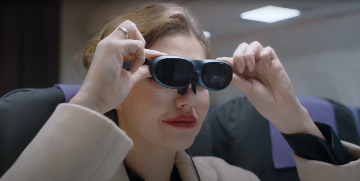 Eine Frau setzt die AR-Brille Rokid Max auf.