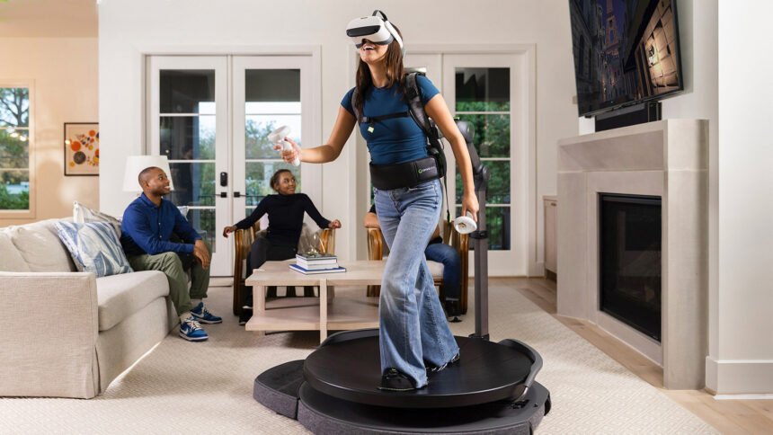 Eine Frau nutzt im Wohnzimmer das Virtuix-Laufband. Im Hintergrund Freunde, die das VR-Geschehen auf einem Fernseher mitverfolgen.