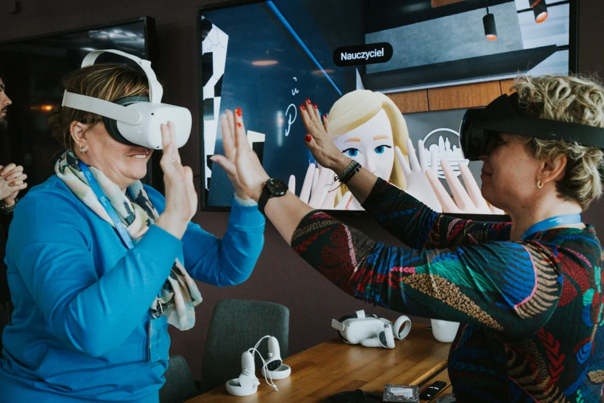 Zwei Frauen mit VR-Brillen klatschen gegenseitig in ihre Hände.