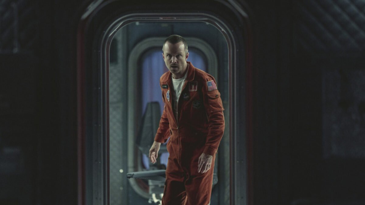 Schauspieler Aaron Paul geht in einem Raumanzug durch eine Luke in der Serie Black Mirror.