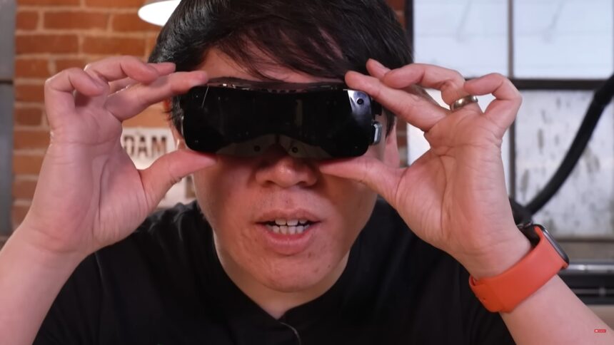 Norman Chan von Adam Savage's Tested hält sich das Bigscreen Beyond Headset vors Gesicht.