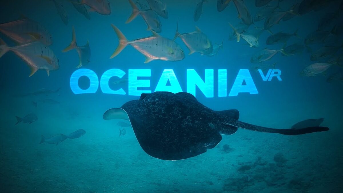 Ein schwarzer Rochen gleitet durch einen azurblauen Ozean, dahinter der Schriftzug Oceania VR.