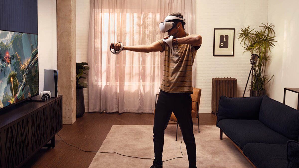 Ein junger Mann spielt in seinem Wohnzimmer mit Playstation VR 2.