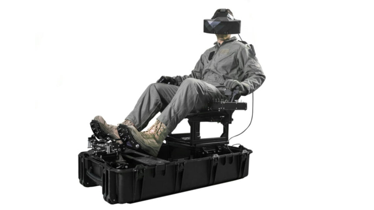 Ein Pilot sitzt in einem aufklappbaren Flugsimulator und trägt einen VR-Brille.