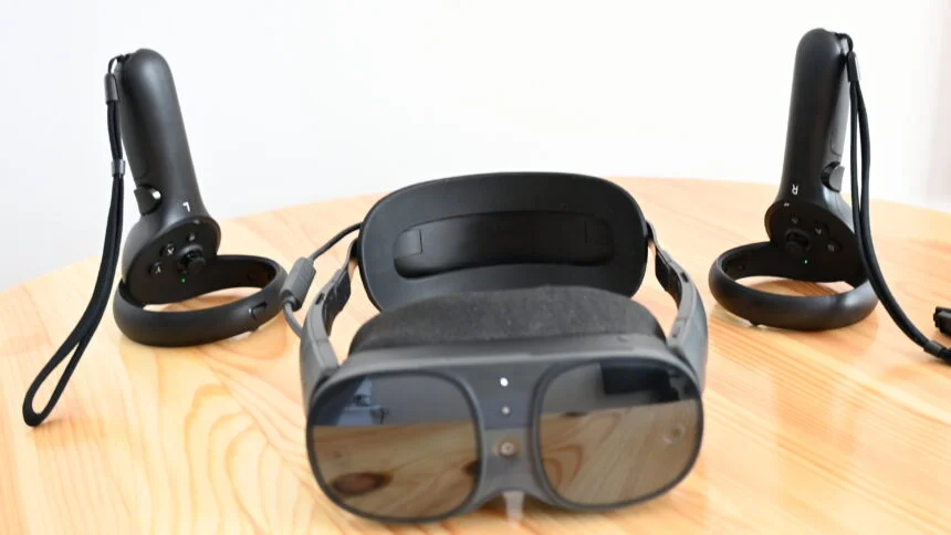 Die VR-Brille Vive XR Elite von vorn auf einem Tisch, rechts und links dahinter die Vive Focus 3 Controller