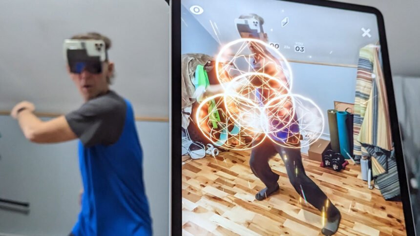 Eine Person trägt ein HoloKit X, während ein iPad im Vordergrund die augmentierte Ansicht zeigt, die sie sieht. 