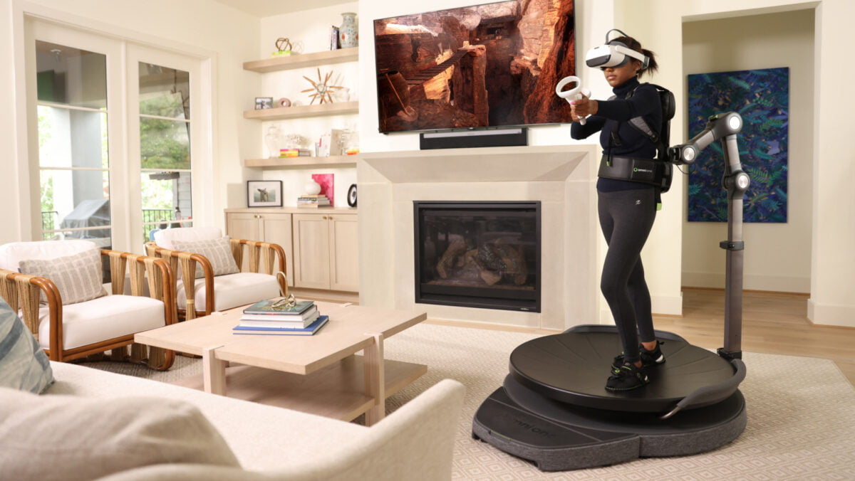Eine junge Frau auf dem im Wohnzimmer stehenden VR-Laufband Virtuix Omni One.