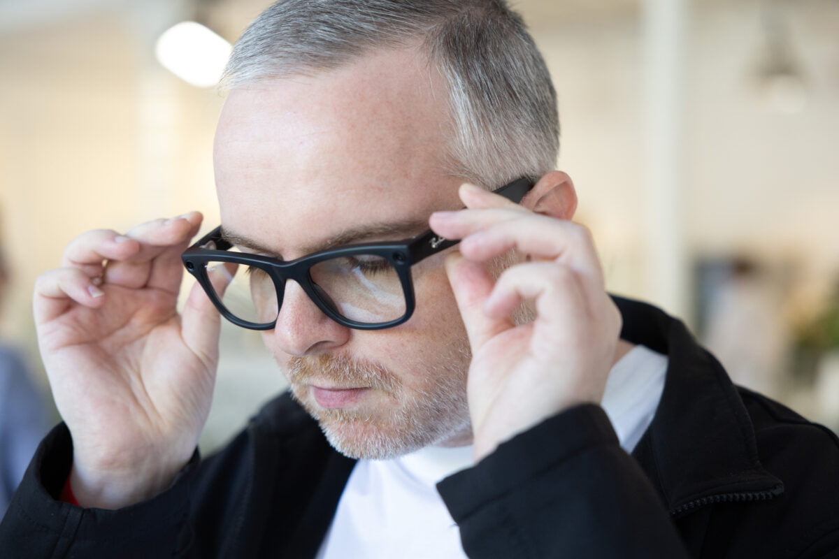 MIXED-Redakteur ben setzt sich schwarze Ray-Ban | Meta Smart Glasses auf und schaut dabei nach unten