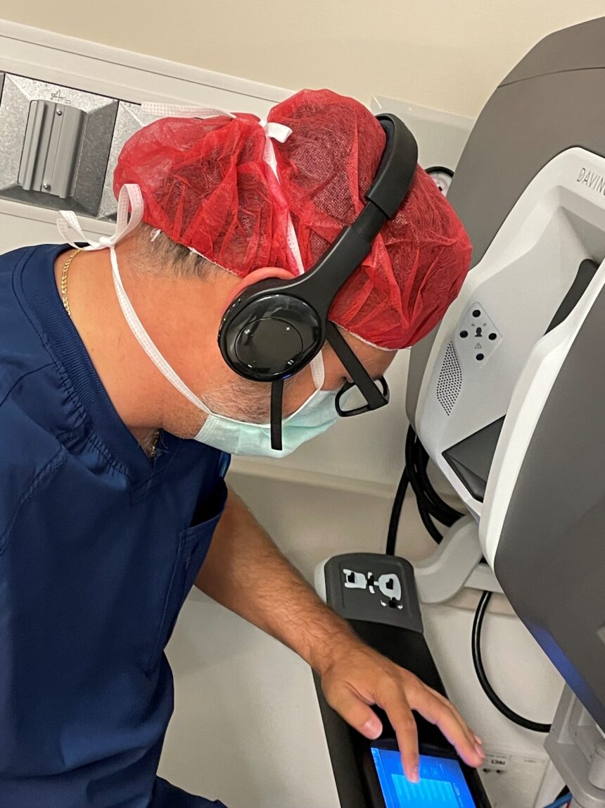 Ein Arzt in OP-Kleidung interagiert mit einem mobilen Gerät und Kopfhörern. 