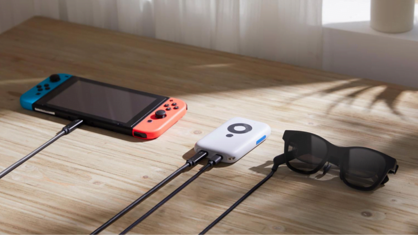 Eine Nintendo Switch, ein Xreal Beam und die Display-Brille Xreal Air 2 liegen auf einem Holztisch und sind per USB-C-Kabel verbunden.