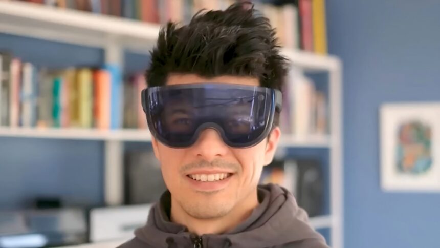 Mann mit futuristischem VR-Headset, das die Augen des Benutzers mit Hilfe von Reverse Passthrough zeigt. 