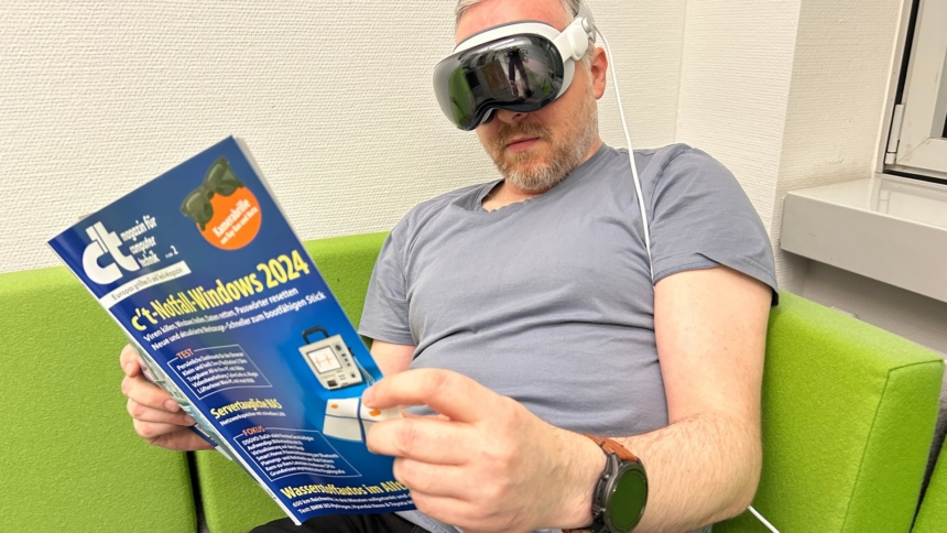 Mann mit c't-Magazin in der Hand auf der Couch während er eine Apple Vision Pro trägt
