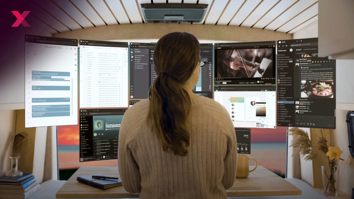 Eine Frau steht vor einem virtuellen Multi-Monitor-Setup.