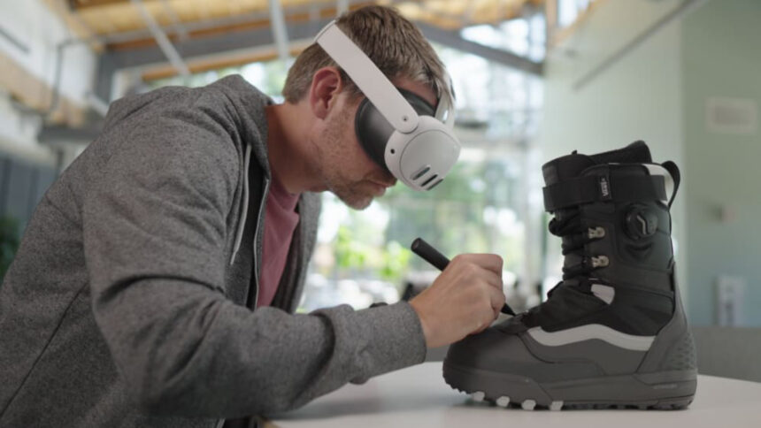 Ein Mann mit VR-Brille schreibt auf einem Skistiefel.